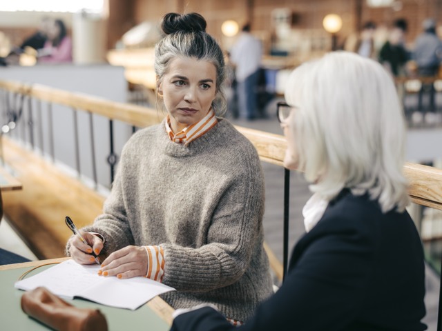 Två sittande gymnasielärare samtalar i korridor Gymnasieskola - övrigt