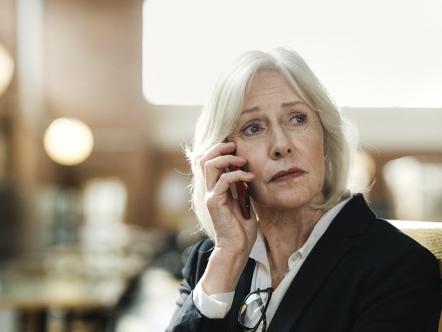 Bekymrad kvinnlig gymnasielärare talar i telefon Gymnasieskola - porträtt