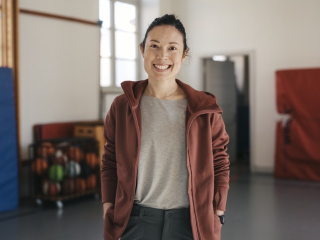 Leende idrottslärare i gymnastiksal Grundskola - porträtt