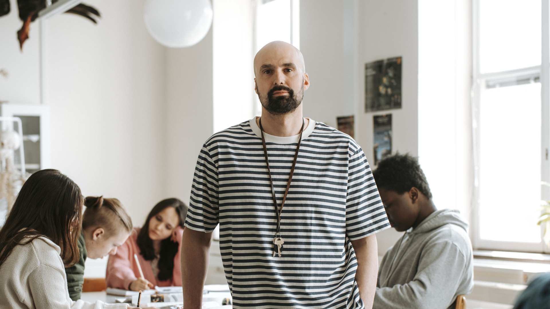 Allvarlig gymnasielärare med elever i lektionssal Gymnasieskola - övrigt