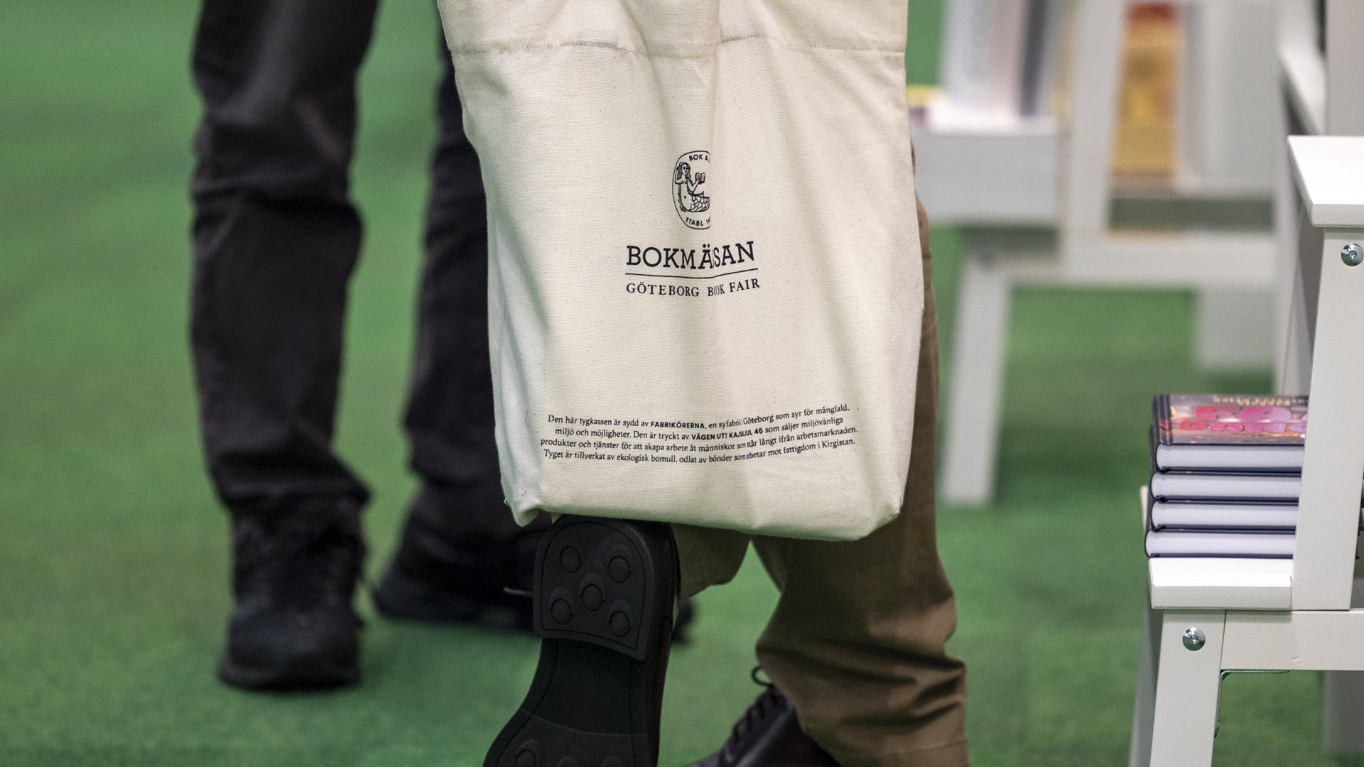 Bokmässan - Tygkasse Bild från mässgolvet, man med bokmässans tygkasse.