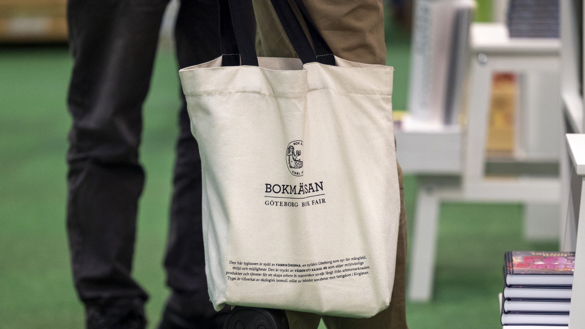Bokmässan - Tygkasse Bild från mässgolvet, man med bokmässans tygkasse.