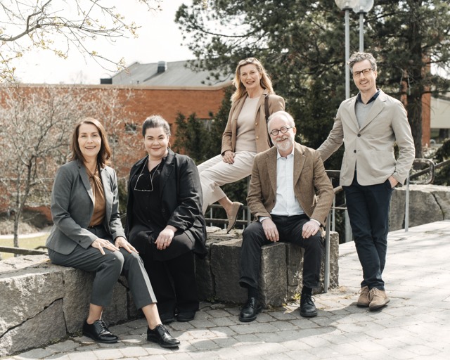 En grupp leende lärare vid högskola utomhus Högskola - gruppbild