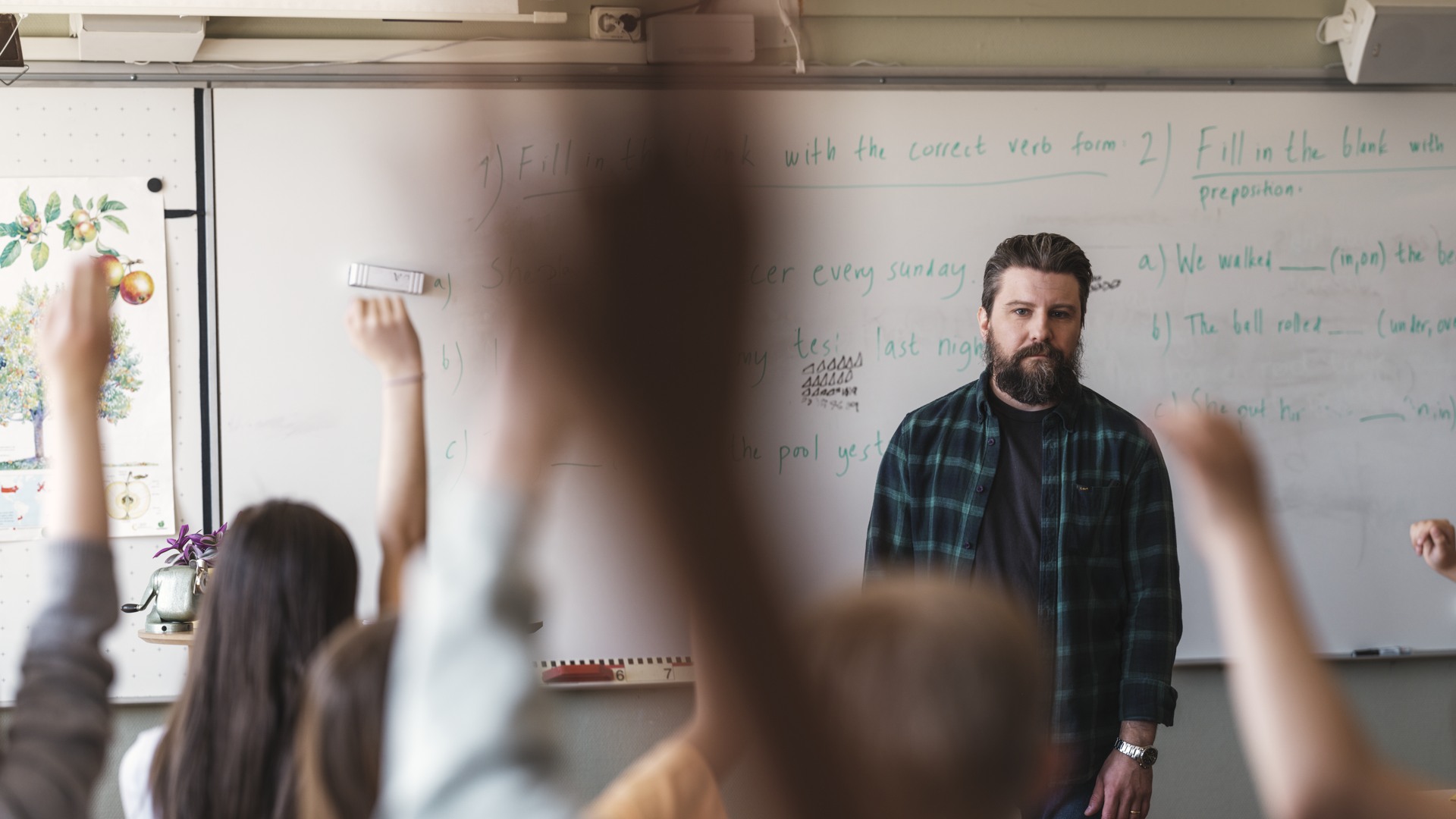 Grundskollärare med elever i klassrum - handuppräckning Grundskola - övrigt