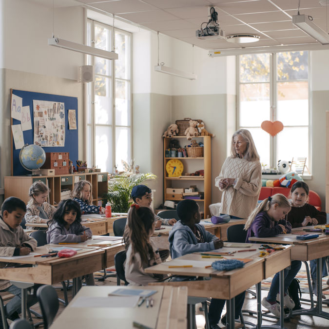 Förskollärare med elever i klassrum.