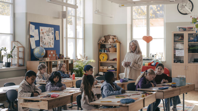 Lärare med elever i klassrum.