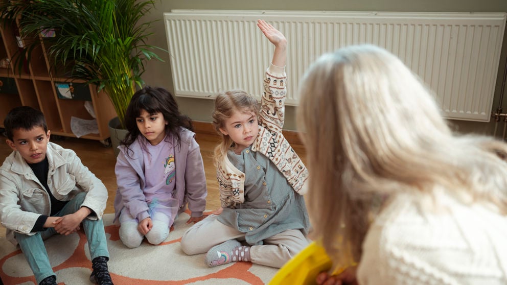 Förskollärare och elever har samling.