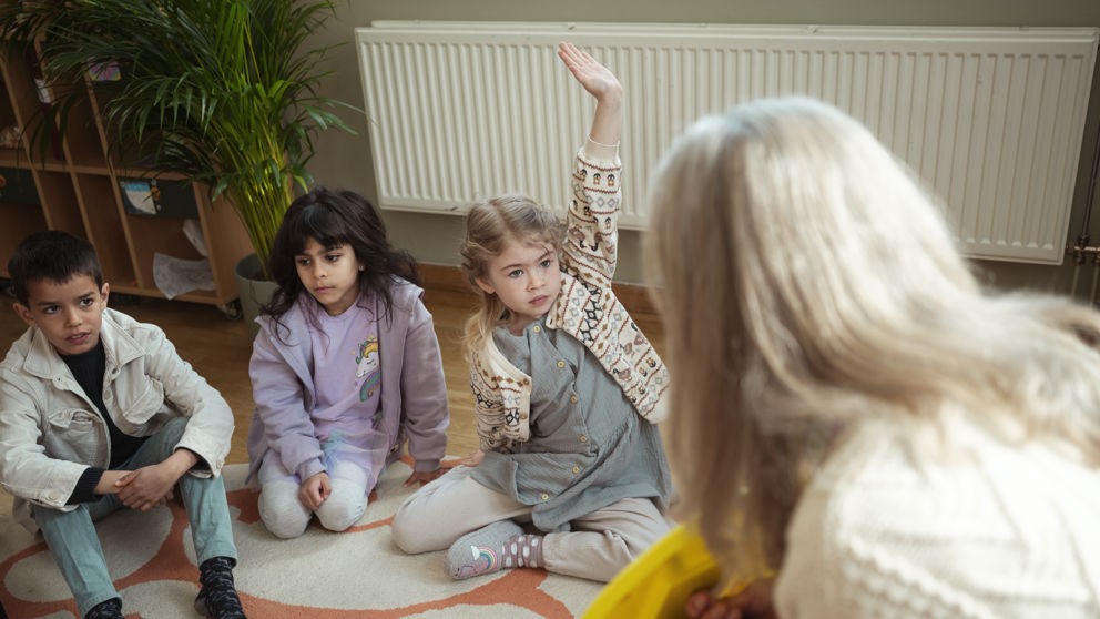 Förskollärare och elever har samling.