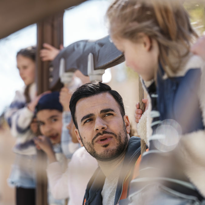 Förskollärare pratar med elev utomhus.