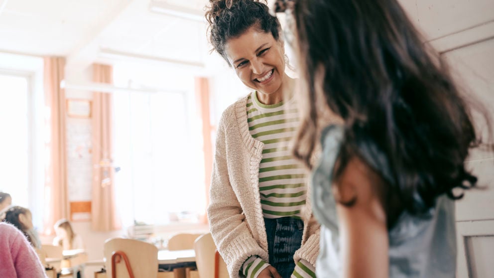 Lärare pratar med en elev inomhus.