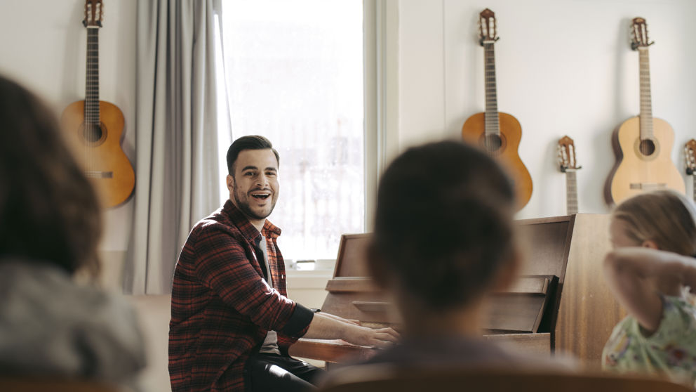 Förskollärare med elever under musiklektion.