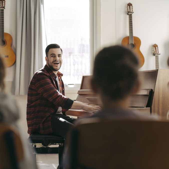 Förskollärare med elever under musiklektion.