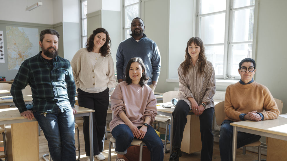 Sex glada grundskollärare inomhus.