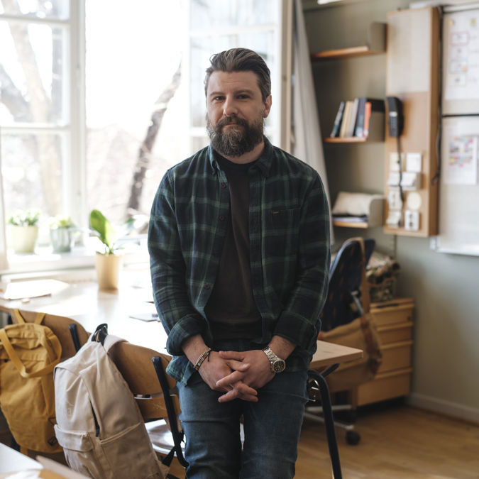 Allvarlig manlig grundskollärare i ett klassrum.