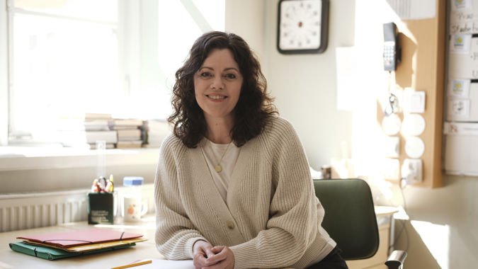 Leende kvinnlig grundskollärare inomhus.