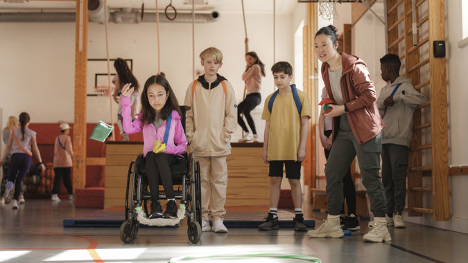 Idrottslektion pågår i en gymnastiksal.