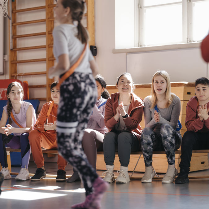 Idrottslektion pågår i en gymnastiksal.