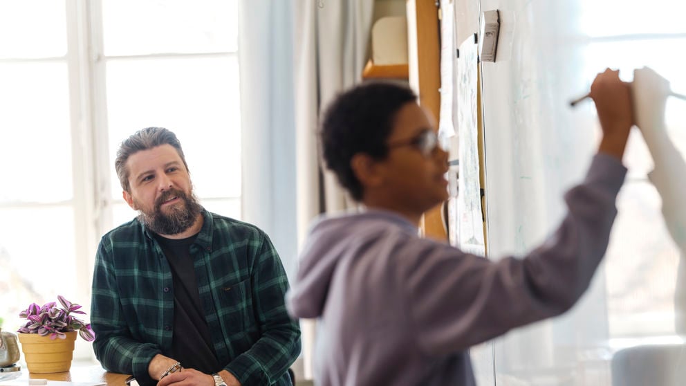 Pojke skriver på whiteboard.