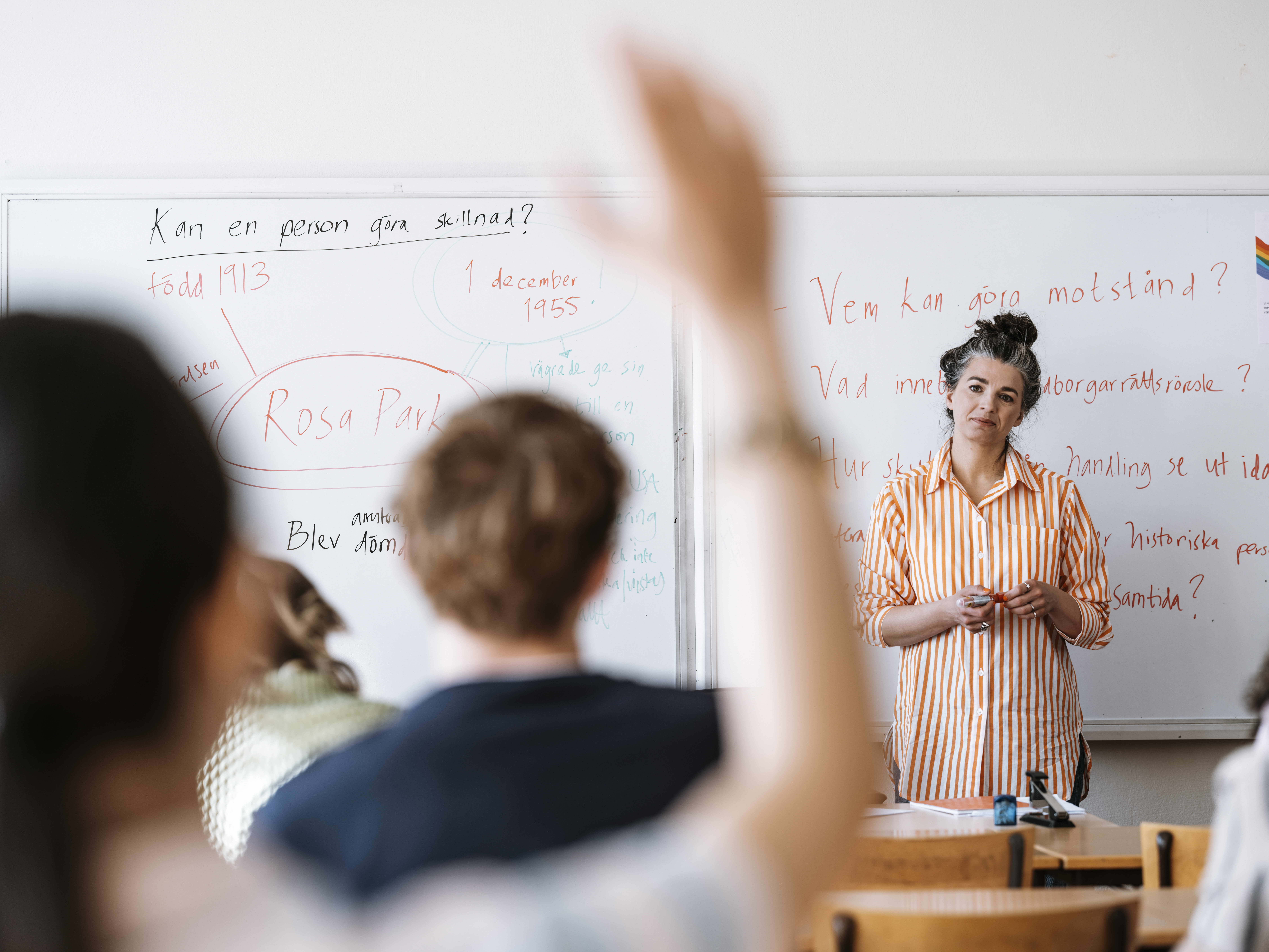 Gymnasieflicka räcker upp handen.