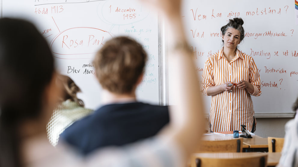 Gymnasieflicka räcker upp handen.