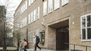 Gymnasielärare på väg ut ur skolbyggnad.