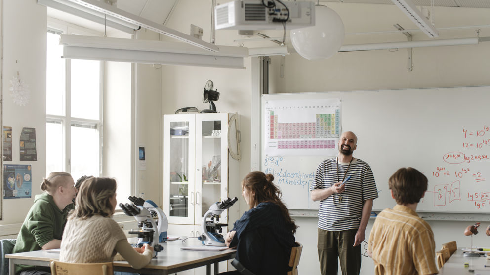 Gymnasielärare med elever under lektion i biologi.