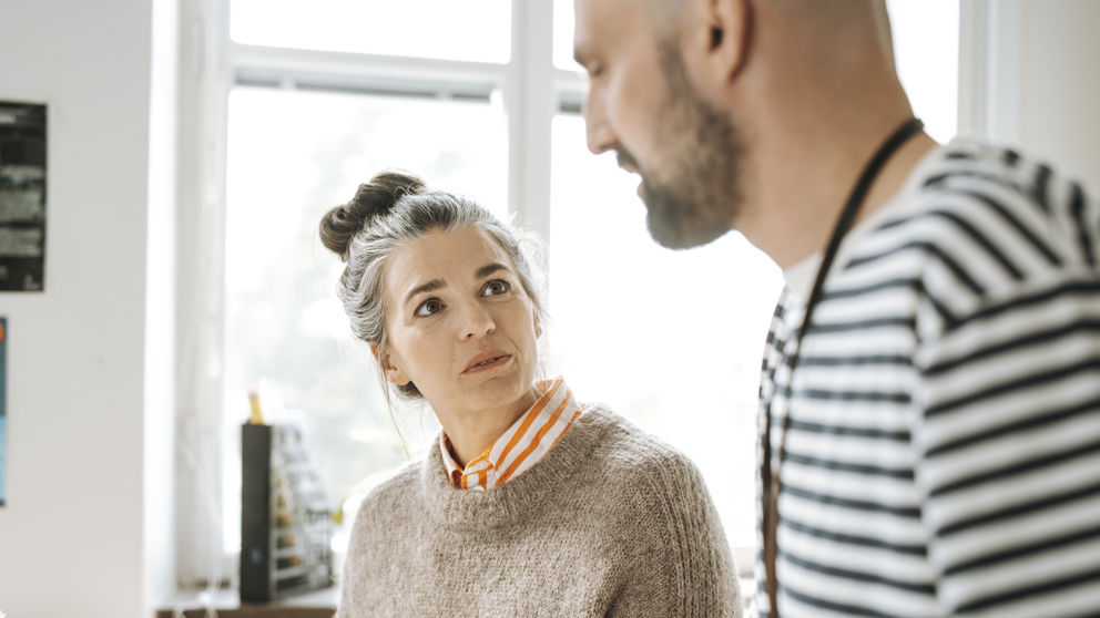 Två gymnasielärare under samtal inomhus.