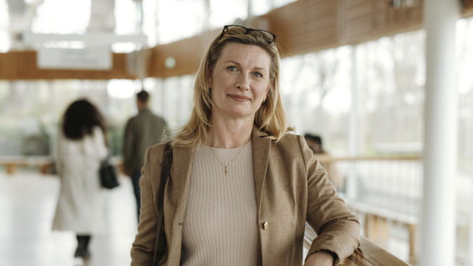 Kvinnlig lärare vid högskola inomhus.