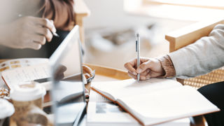 Student vid högskola antecknar med penna.