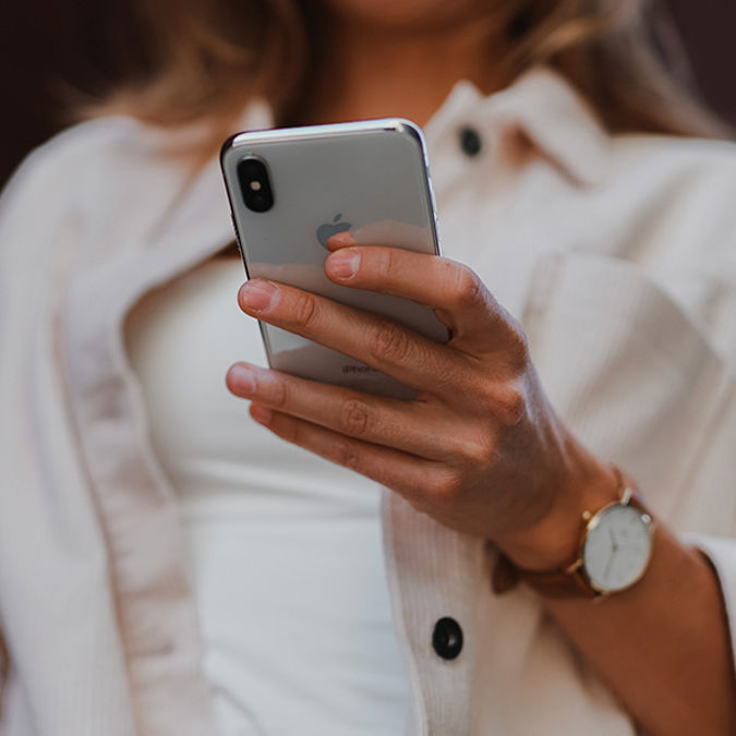 Kvinna som tittar på sin mobiltelefon
