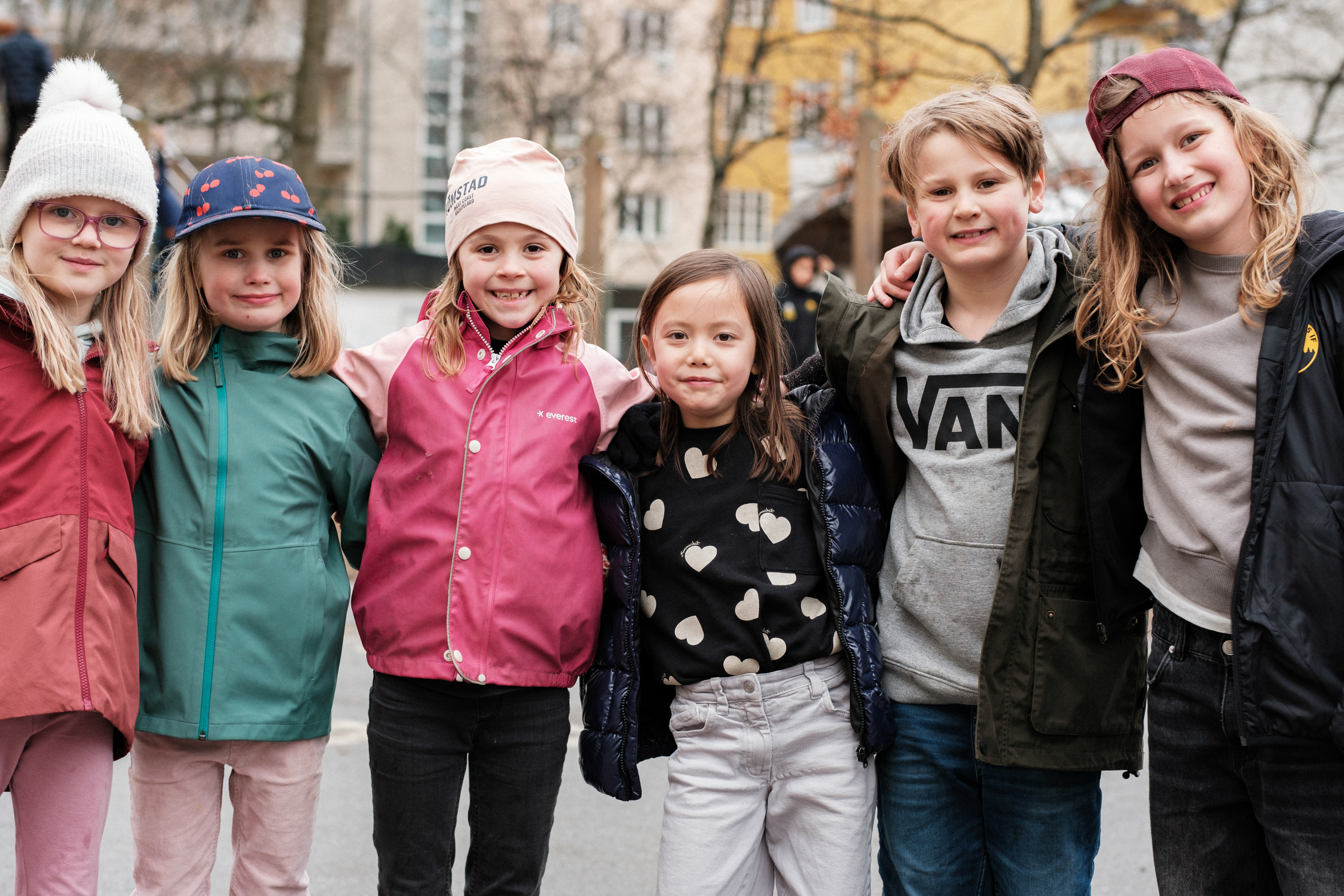 Glada elever på Karlbergs fritidshem poserar utomhus.