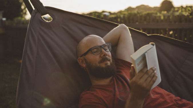 Man läser i hängmatta