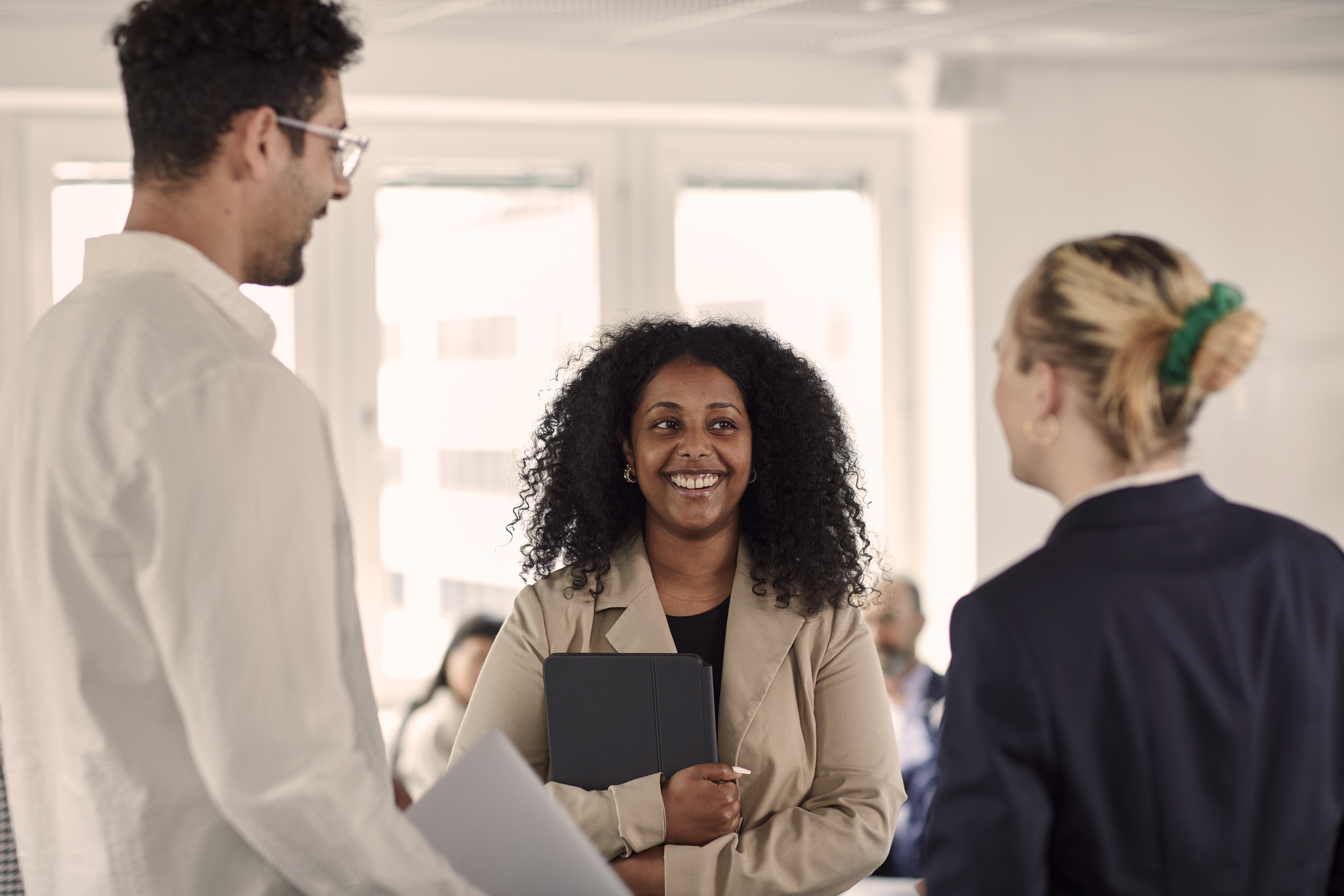 Tre kollegor samtalar i kontorsmiljö Tre kollegor samtalar i kontorsmiljö Tre kollegor samtalar i kontorsmiljö