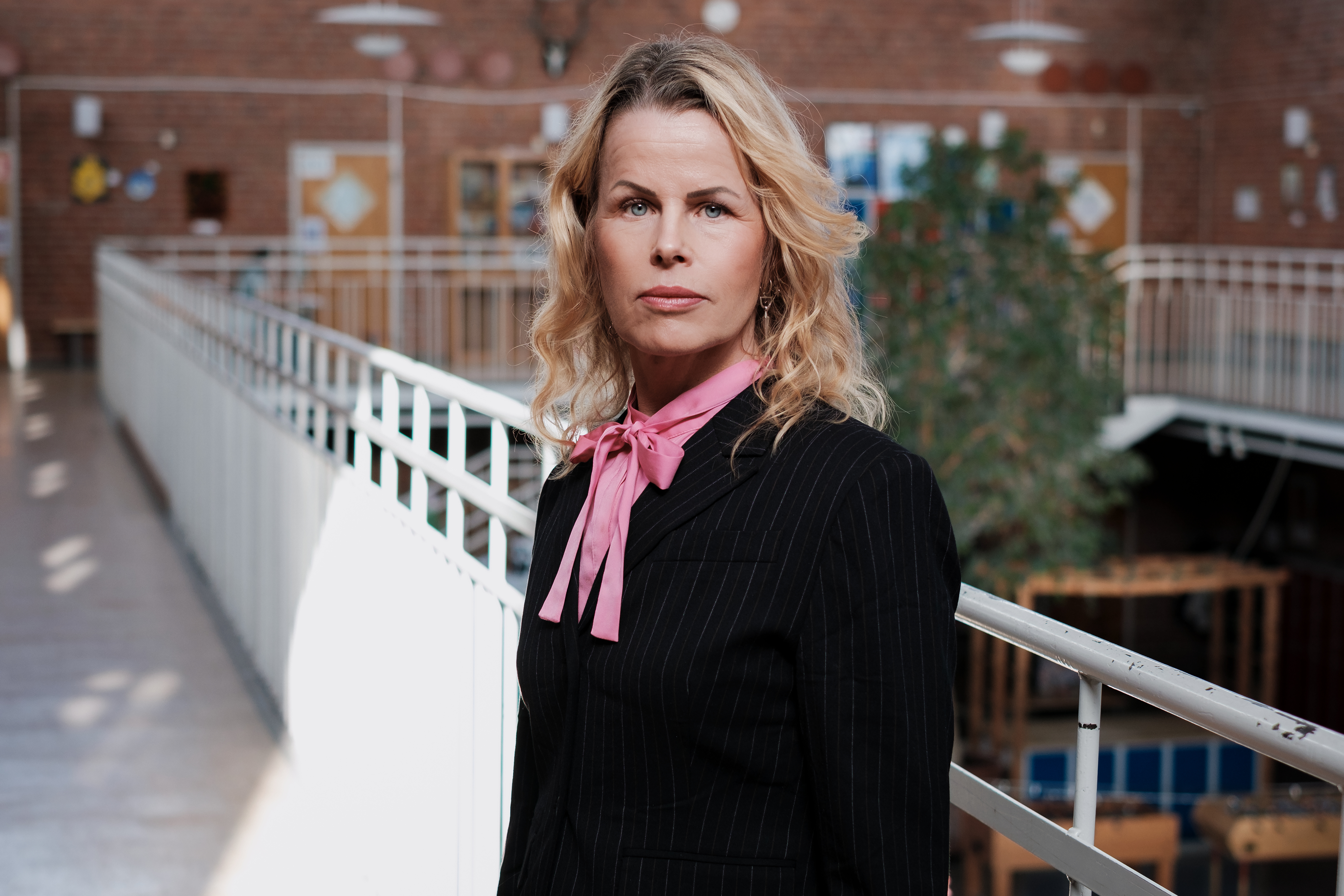 Förbundsordförande Anna Olskog med allvarlig blick i skolkorridor.