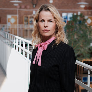 Förbundsordförande Anna Olskog med allvarlig blick i skolkorridor.
