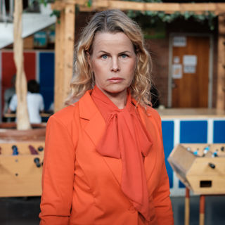 Förbundsordförande Anna Olskog med allvarlig blick i skolmiljö.