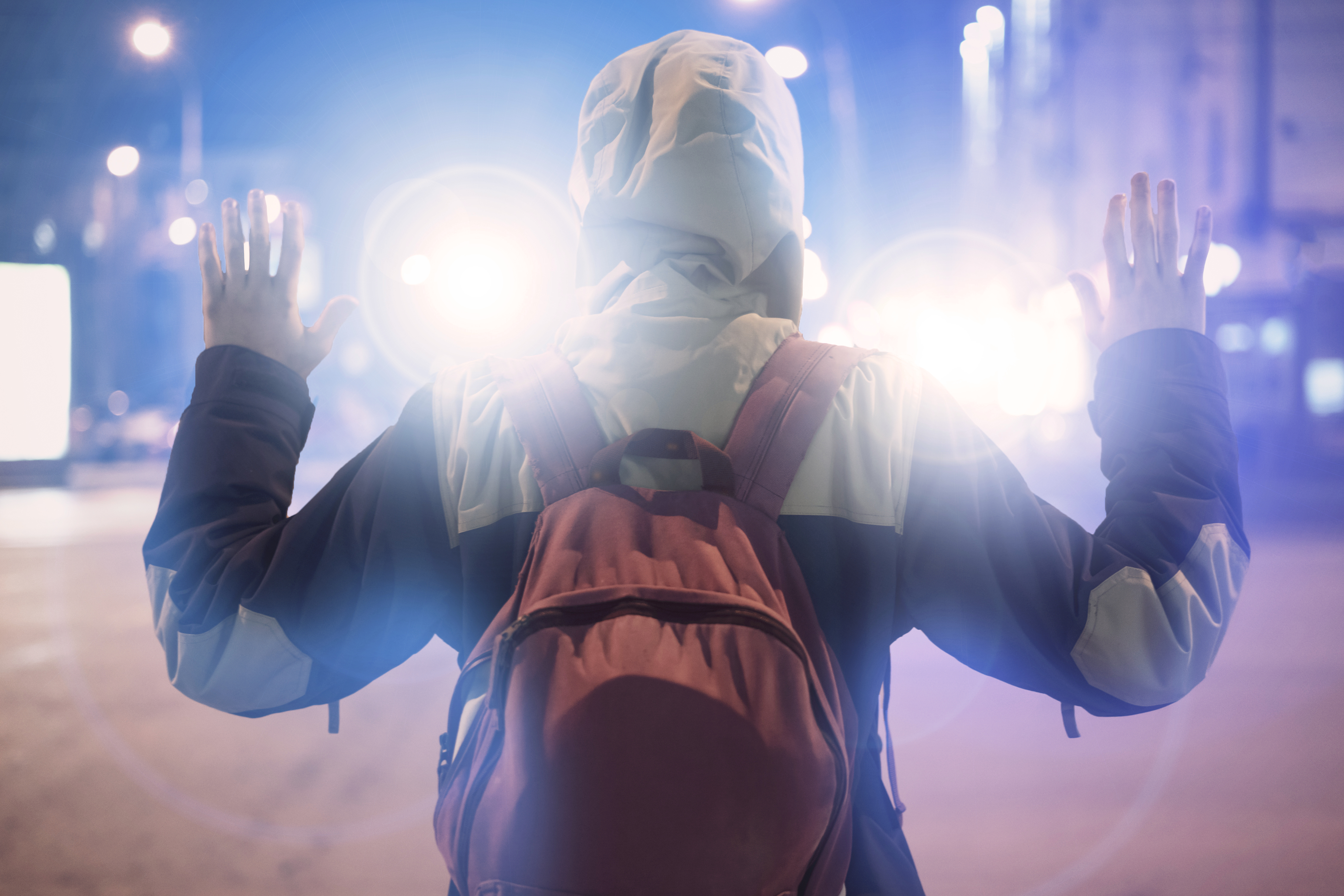 male suspect arrested in the night city, with police flashers behind him male suspect arrested in the night city, with police flashers behind him male suspect arrested in the night city, with police flashers behind him