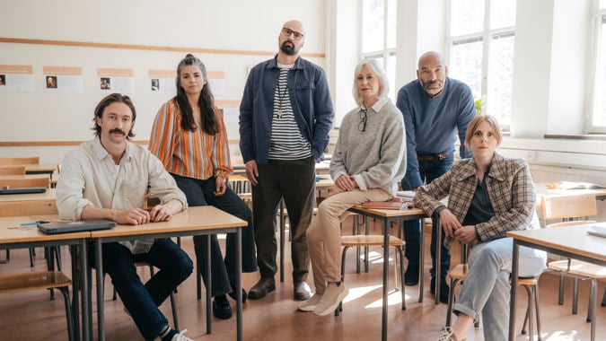 En grupp allvarliga gymnasielärare i ett klassrum.